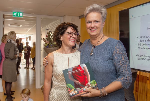 Janny van de Laar (l.) overhandigt haar eerste boek aan patiënte Marie-Joze van Riel.